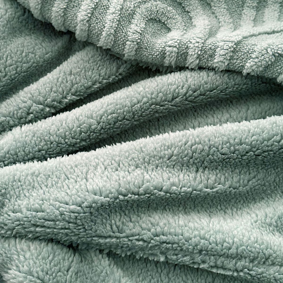 Plush sage fleece surface with embossed pattern in soft lighting