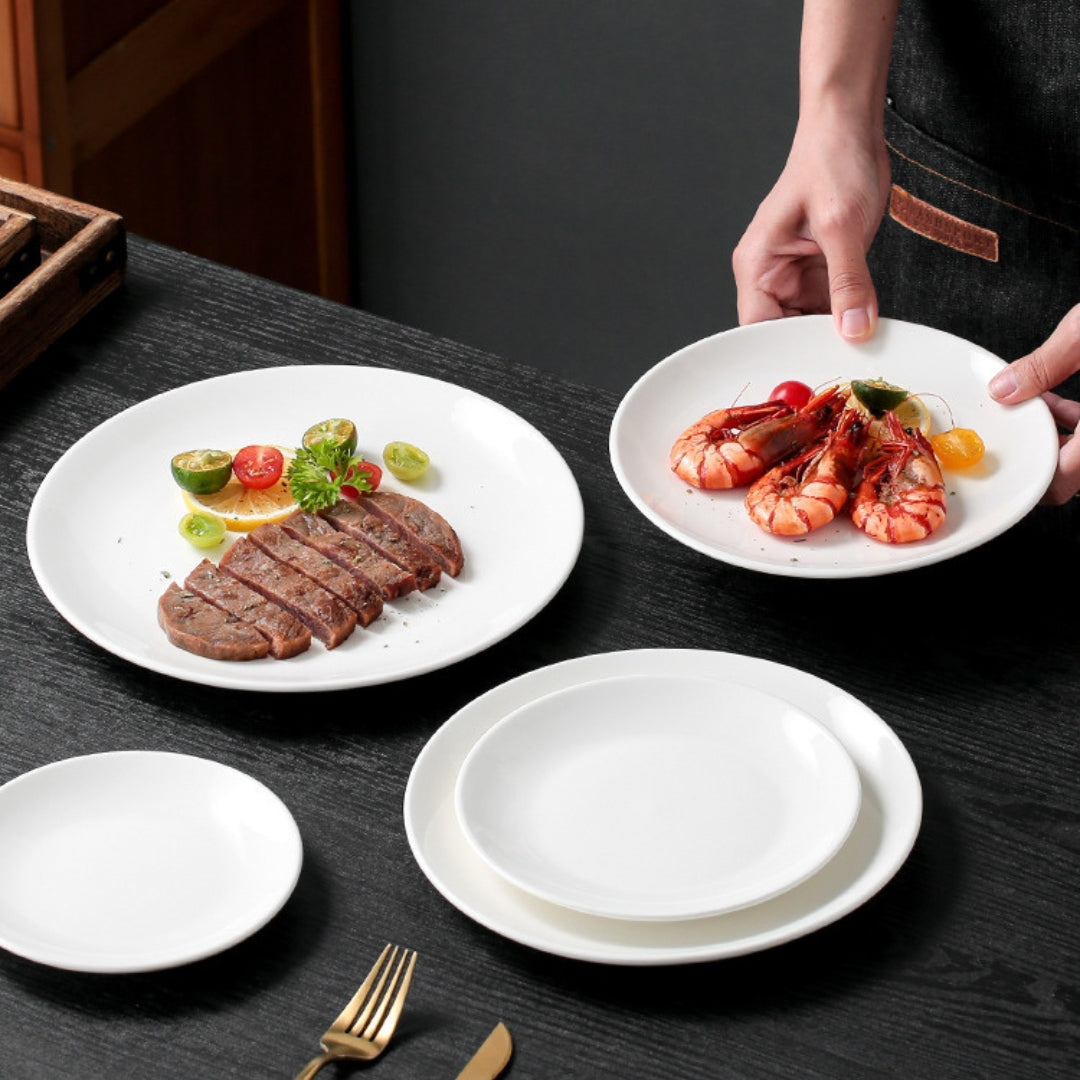 Serving steak and shrimp on white plates, minimal dinner table setting