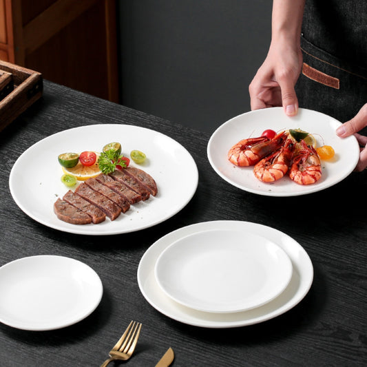 Serving steak and shrimp on white plates, minimal dinner table setting