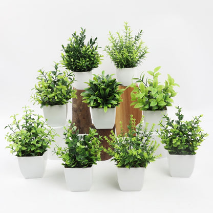 Collection of artificial potted plants arranged on display with white pots