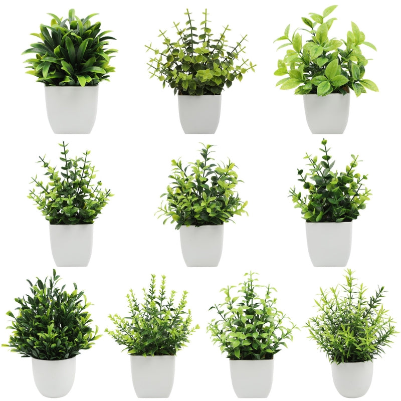 Collection of artificial potted plants arranged on display with white pots