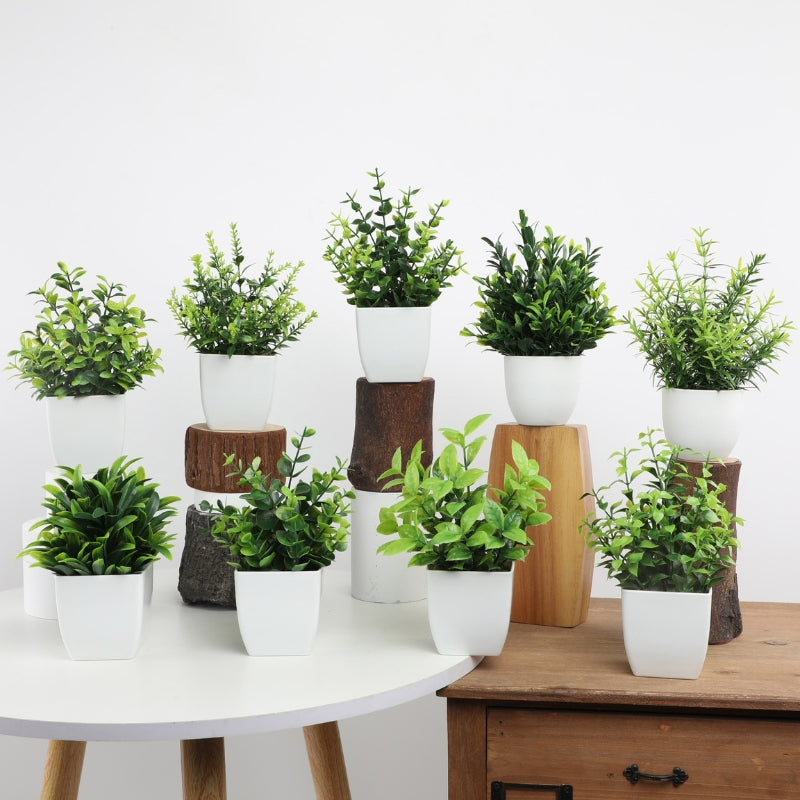 Artificial potted plants in white pots displayed on wooden shelf and stands