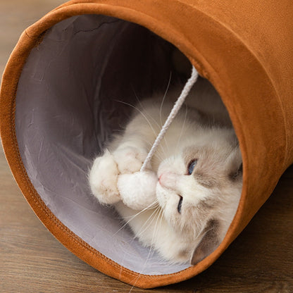 Cat lying inside tunnel toy playing with hanging ball