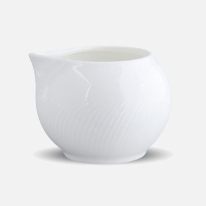 CAI small round milk pitcher with curved spout, studio image.