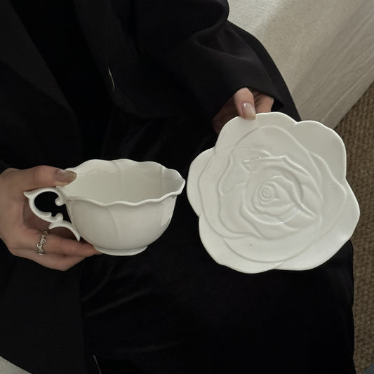 Matching ceramic tea cup and rose-shaped plate, elegantly displayed.