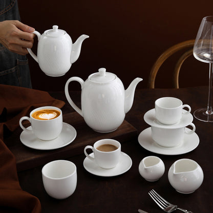CAI ceramic coffee set styled on dark wood table with cappuccino and espresso.