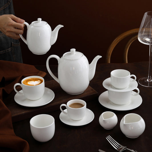 CAI ceramic coffee set styled on dark wood table with cappuccino and espresso.