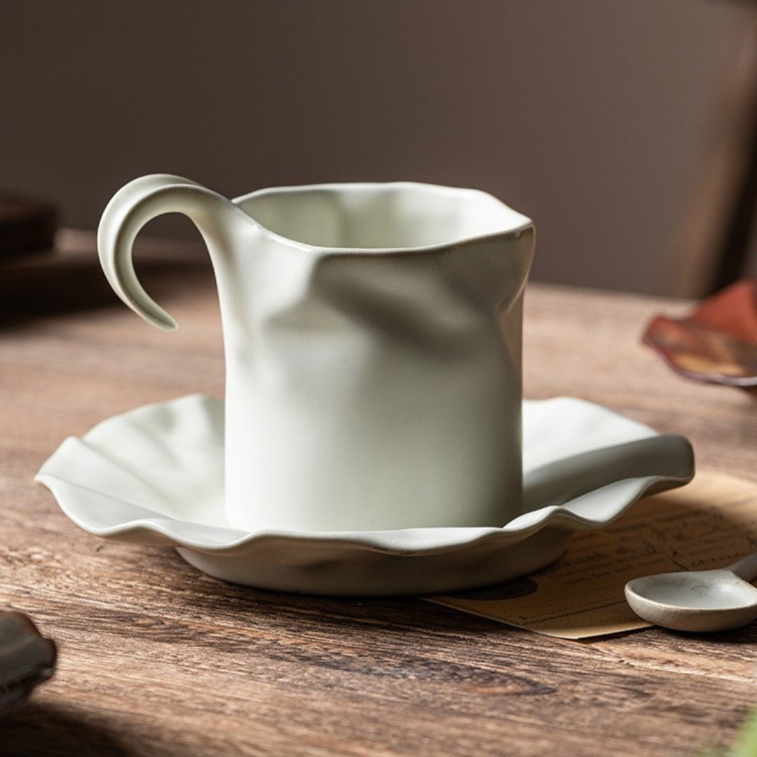 Close-up of handmade ceramic coffee cup filled with black coffee and spoon.