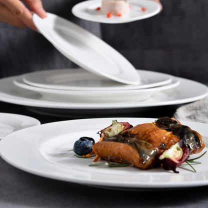 Close-up of grilled salmon dish on white plate with layered stack in background