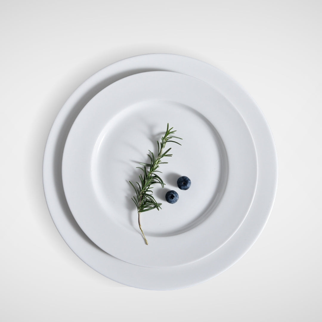 Minimalist plating with rosemary and blueberries on stacked white plates