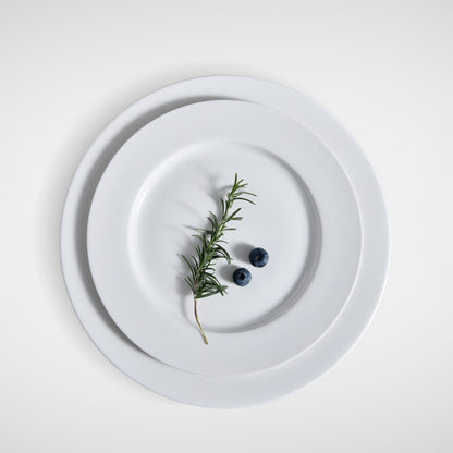 Minimalist plating with rosemary and blueberries on stacked white plates