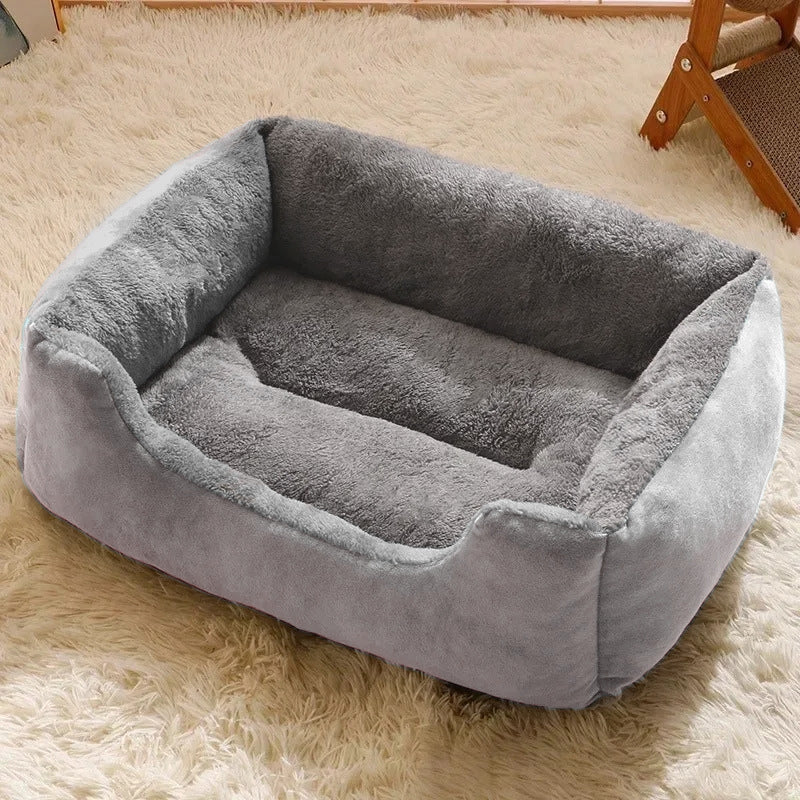 A cozy gray plush pet bed sitting on a light-colored rug in a home setting, showing the product in a realistic environment.