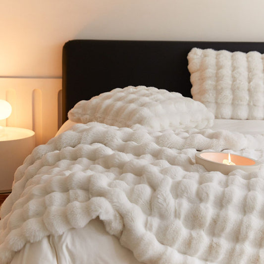 Cream fleece blanket and pillow set styled on modern bed