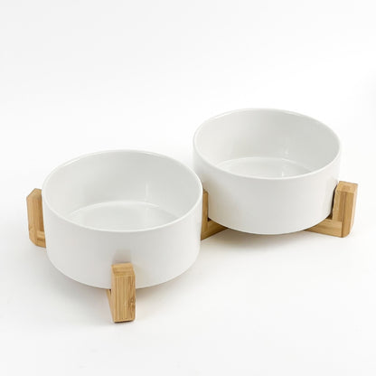 Set of two white ceramic pet bowls with bamboo stand for food and water