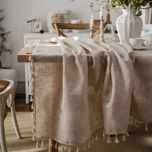 Beige French-style tassel tablecloth draped over a wooden table