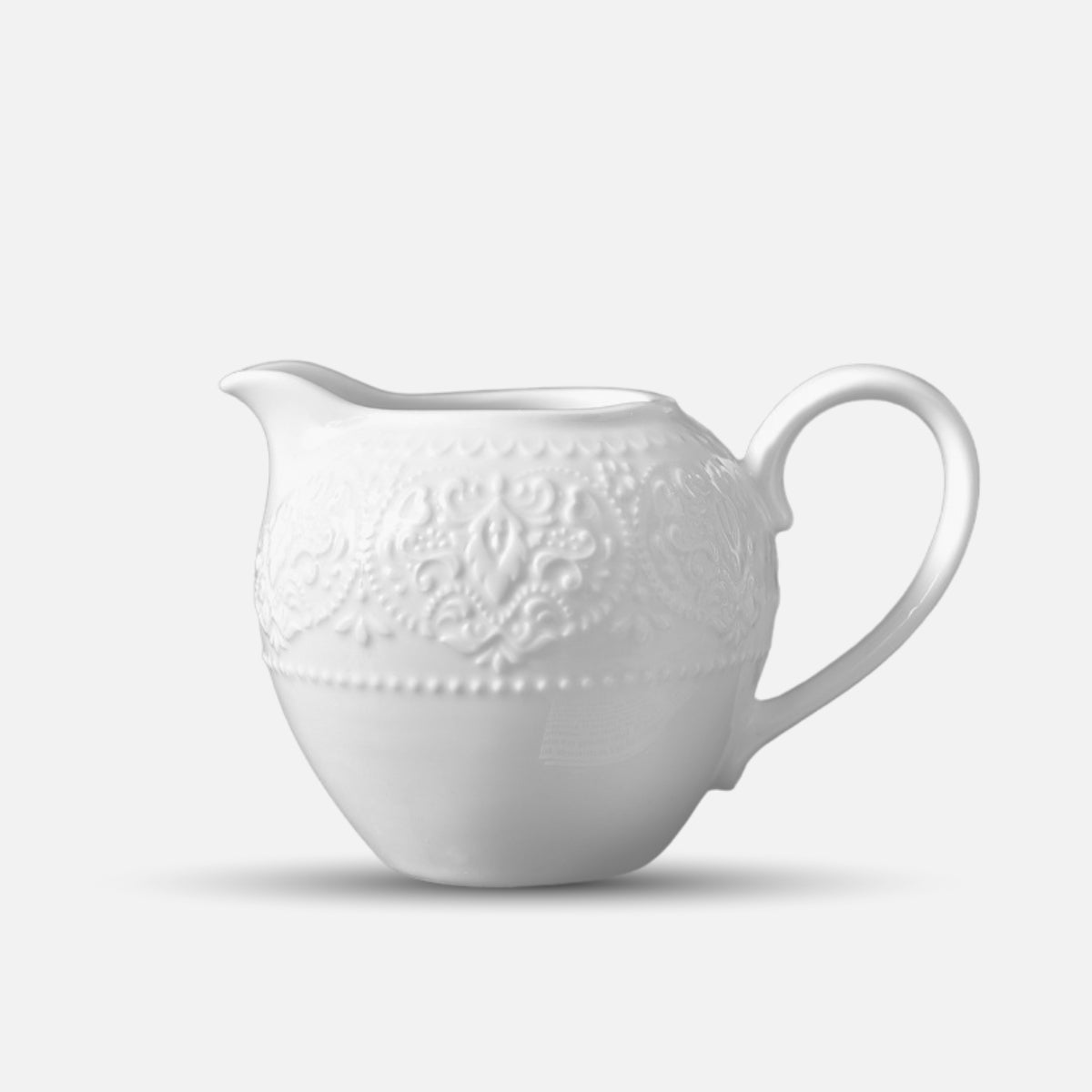 JUN HUA ceramic milk jug with intricate embossed design and round shape.