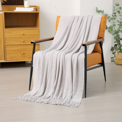 Light gray knitted throw blanket on orange armchair