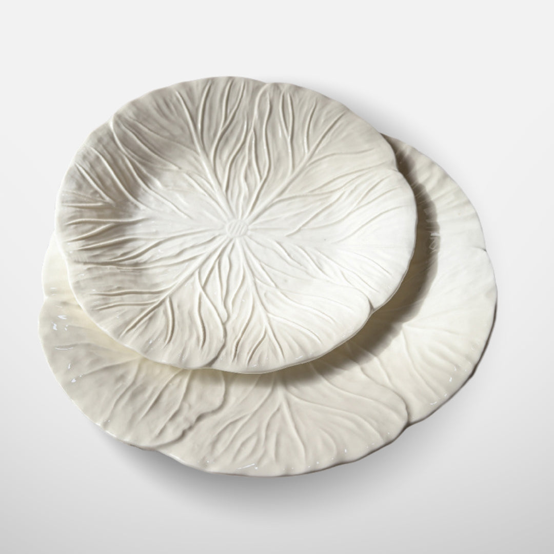 Angled view of two white ceramic leaf plates stacked together