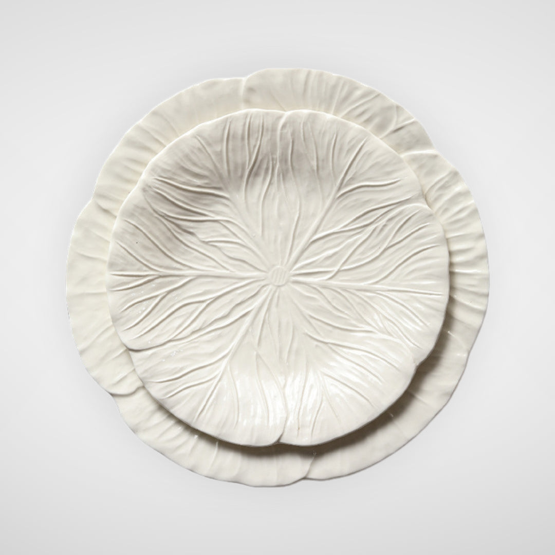 Stacked white ceramic plates with embossed leaf pattern, top view