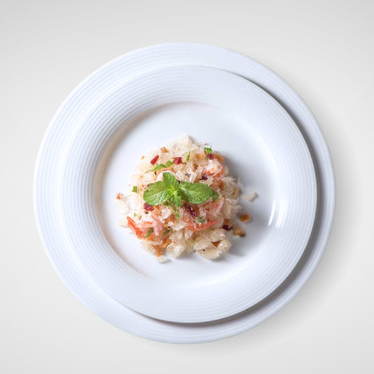 Top view of food served on stacked white plates with textured rim