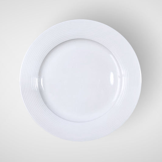 White ceramic plate with subtle rim texture, top view on light background