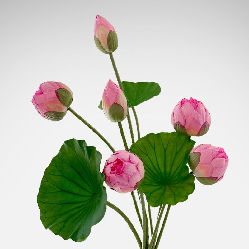 Set of pink artificial lotus flower buds with large green leaves