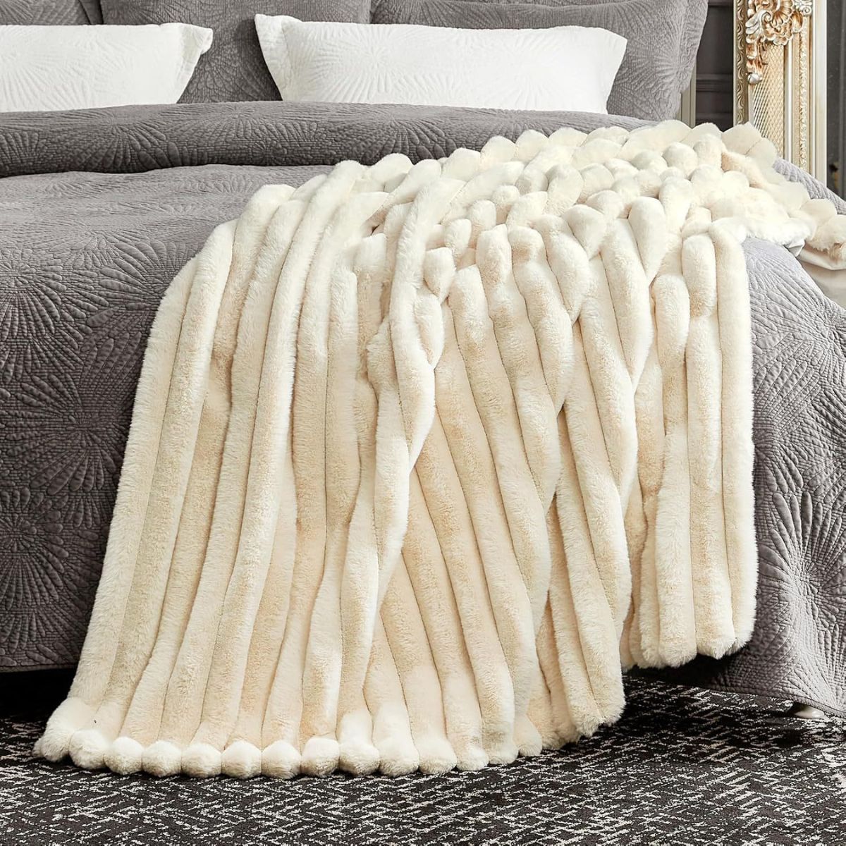 Cream throw blanket styled on a bed