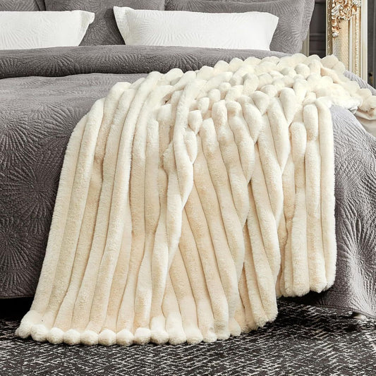Cream throw blanket styled on a bed