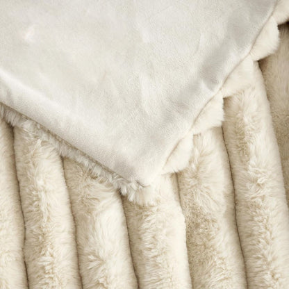 Cream throw blanket styled on a bed