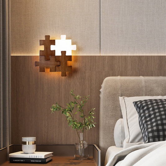 Puzzle piece wooden wall lamp glowing warmly above bedside table