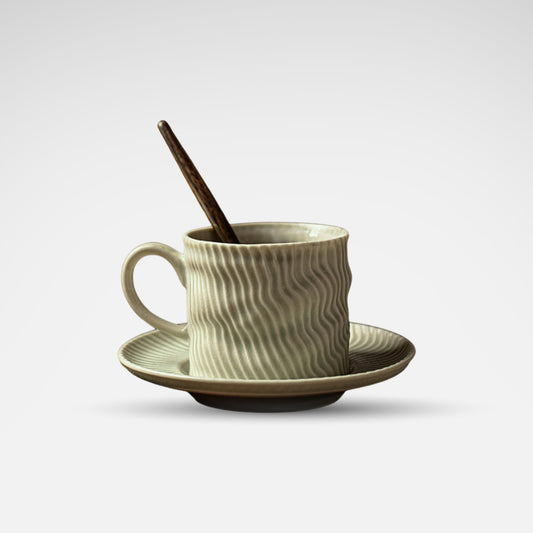 Green ripple-textured ceramic coffee cup and saucer with wooden tray.