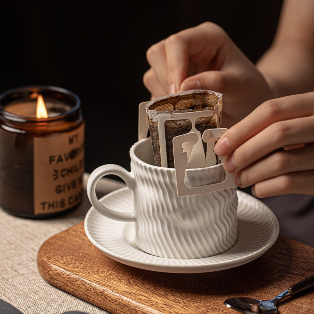 Drip bag brewing in ripple ceramic cup, cozy indoor moment.