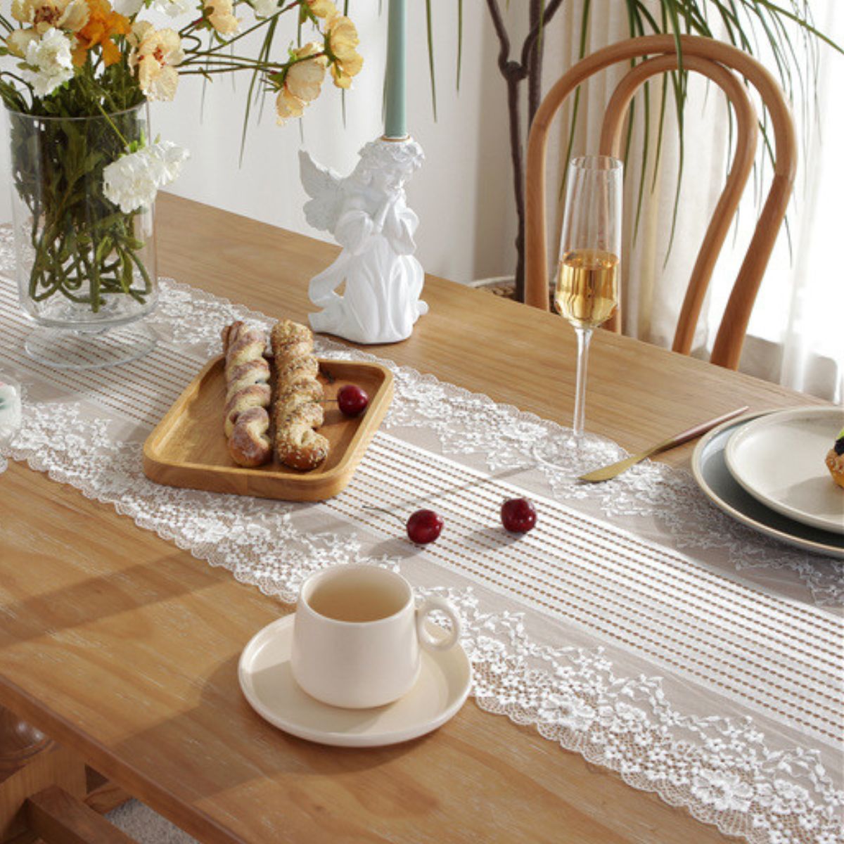 Dining table with lace runner, coffee and decorative setup