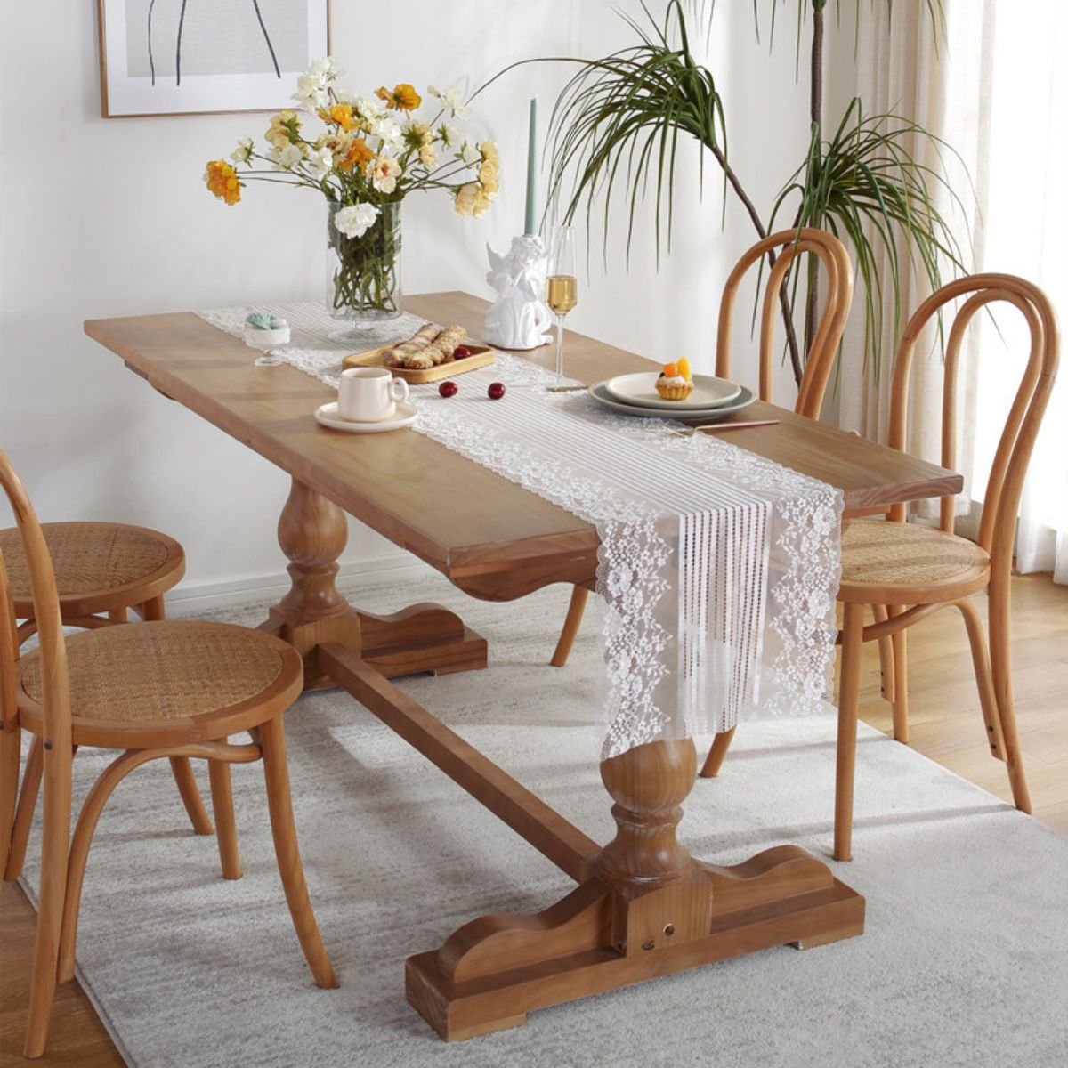 Lace table runner on wooden table with floral arrangement