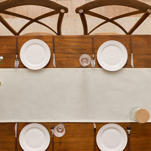 Top view of minimalist beige table runner with plates