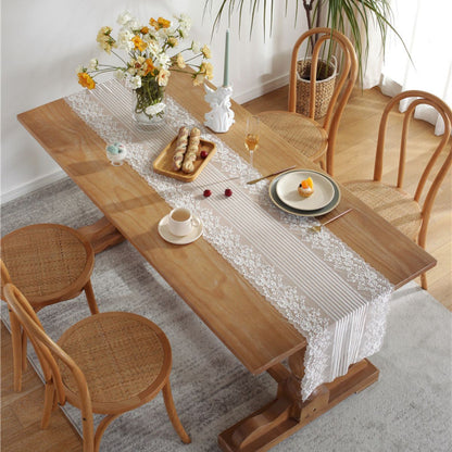 Top view of lace table runner on dining table with food setting