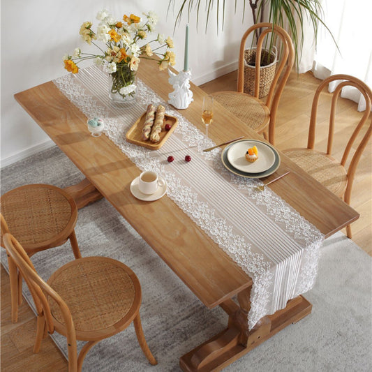 Top view of lace table runner on dining table with food setting