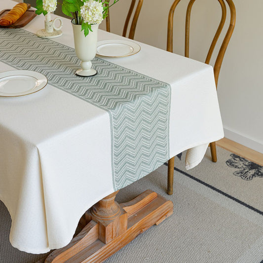 Green zigzag runner on white waterproof tablecloth