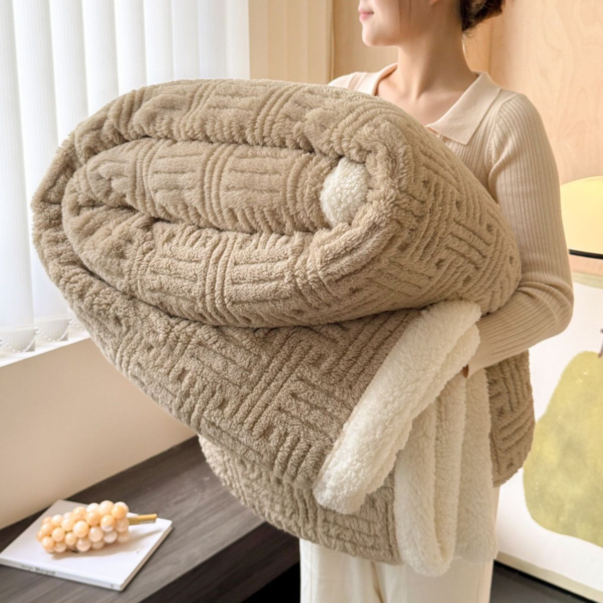Woman holding thick beige sherpa-lined throw blanket
