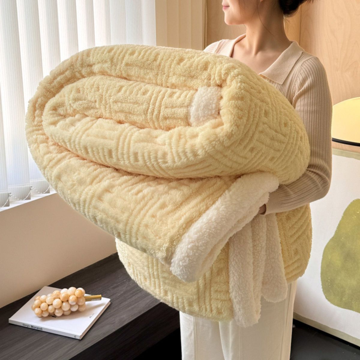 Woman holding warm yellow sherpa throw blanket in cozy indoor setting